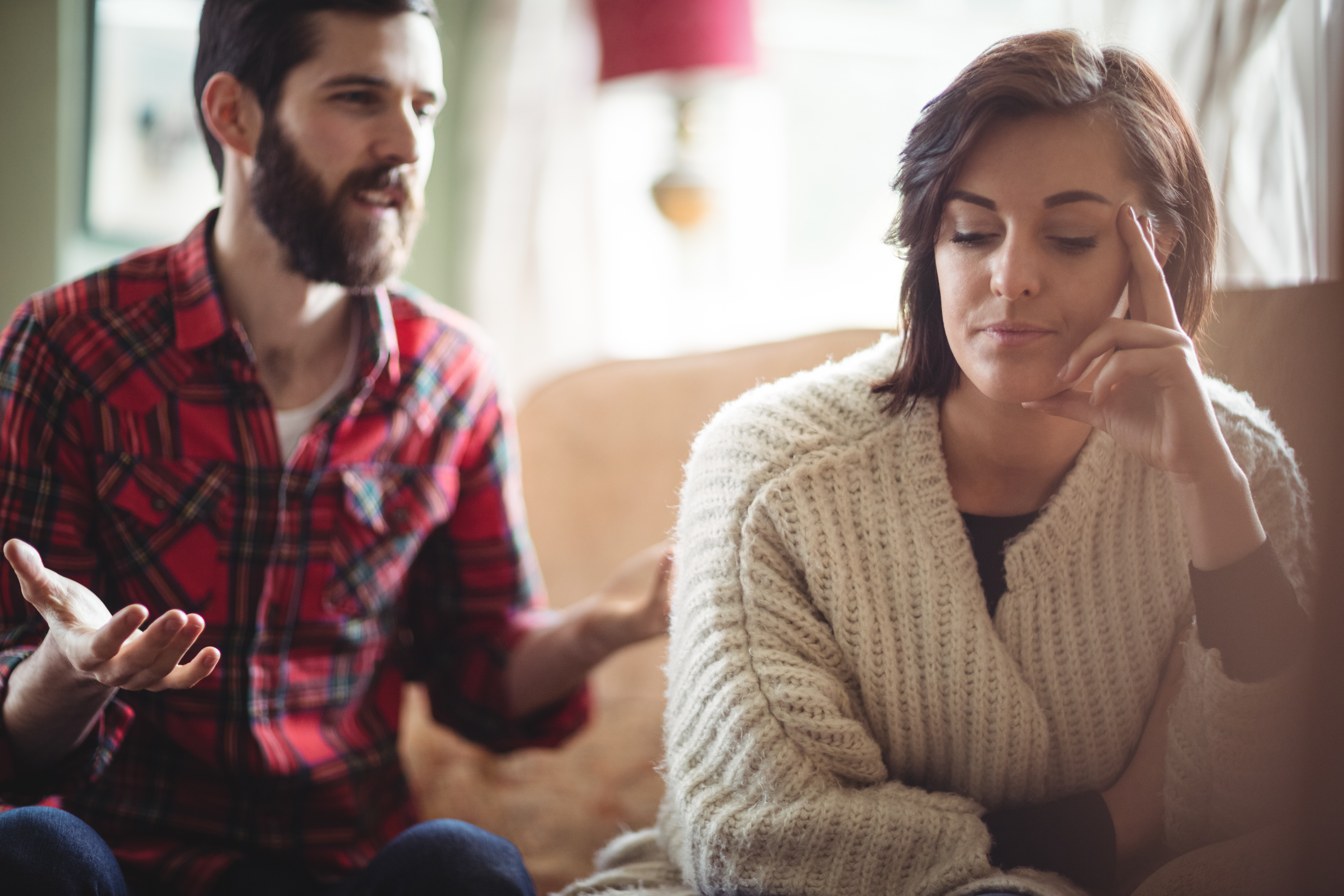 Couple arguing each other in living room at home